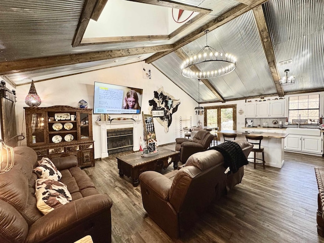 living area featuring a chandelier, lofted ceiling with beams, dark wood-style flooring, and a fireplace