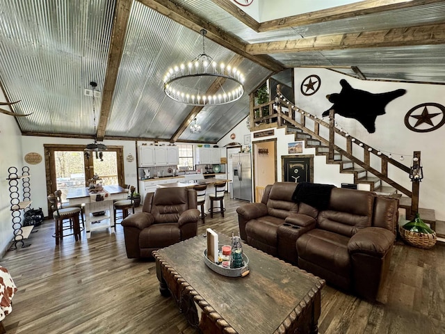 living area with stairway, beam ceiling, and wood finished floors