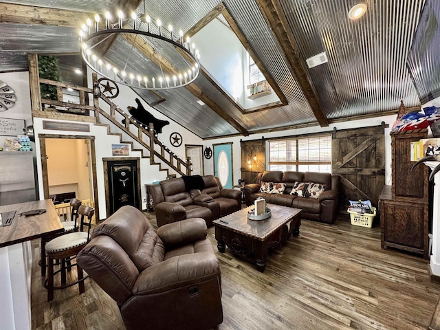 living room with a barn door, wood finished floors, visible vents, stairs, and beam ceiling