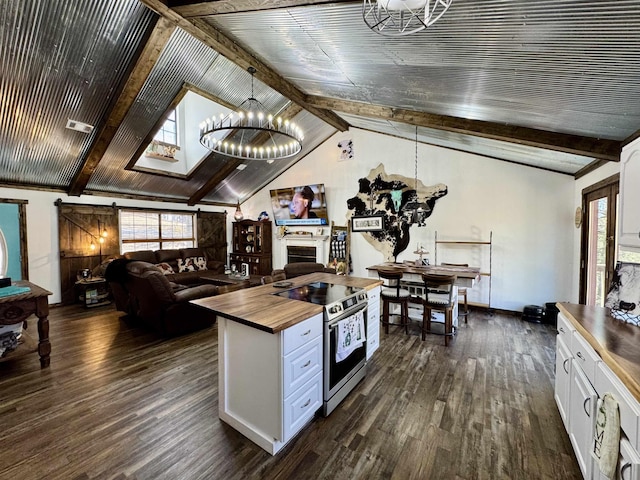 kitchen featuring dark wood-style floors, stainless steel electric range oven, wooden counters, a barn door, and plenty of natural light