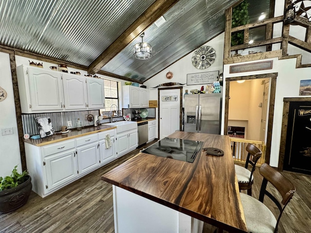 kitchen featuring stainless steel appliances, butcher block counters, white cabinetry, and a sink