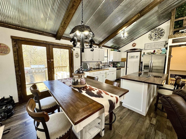 dining area featuring dark wood-style floors, a chandelier, and vaulted ceiling with beams