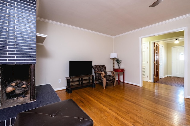 interior space with a brick fireplace, crown molding, and wood finished floors