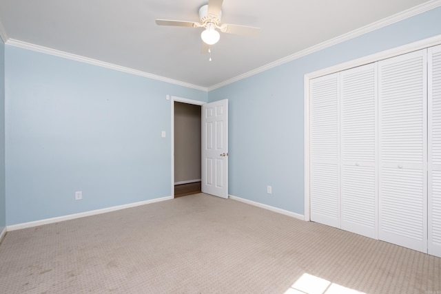 unfurnished bedroom with carpet floors, ornamental molding, a closet, and baseboards