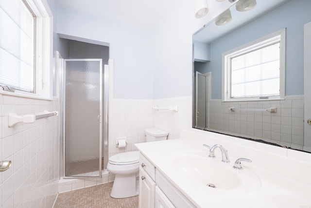 full bathroom with a stall shower, tile patterned flooring, tile walls, and a wainscoted wall