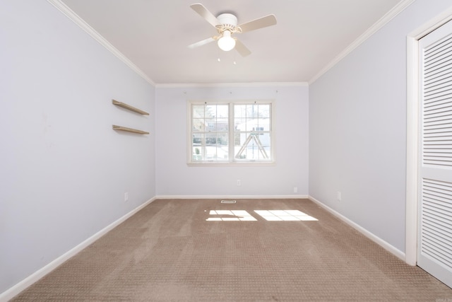 unfurnished room featuring visible vents, baseboards, ceiling fan, crown molding, and carpet floors