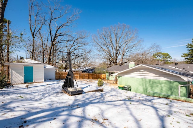 snowy yard with an outdoor structure and fence