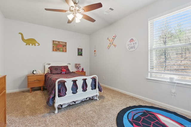 carpeted bedroom with a ceiling fan, multiple windows, visible vents, and baseboards