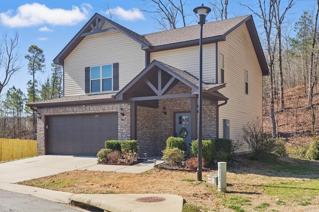 view of front of property with a garage, brick siding, driveway, and fence