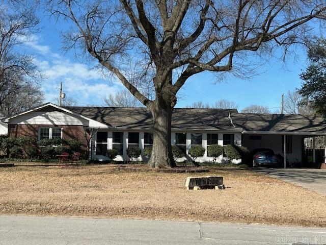 ranch-style house featuring an attached carport and concrete driveway