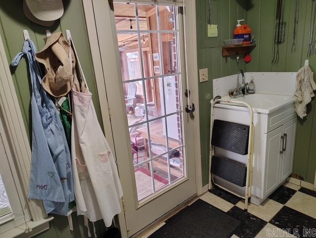 doorway featuring light floors, a wealth of natural light, and a sink