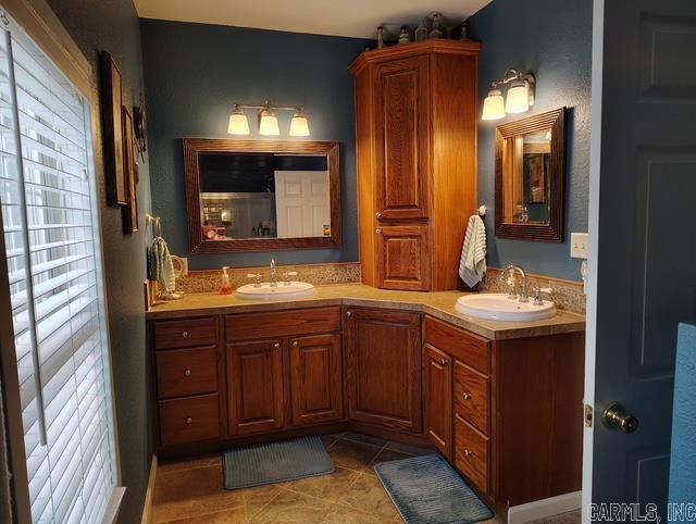 bathroom with double vanity, tile patterned flooring, and a sink