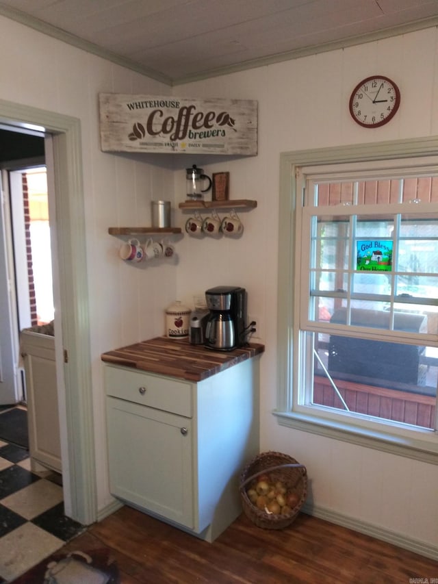 bar with dark wood-style flooring and crown molding