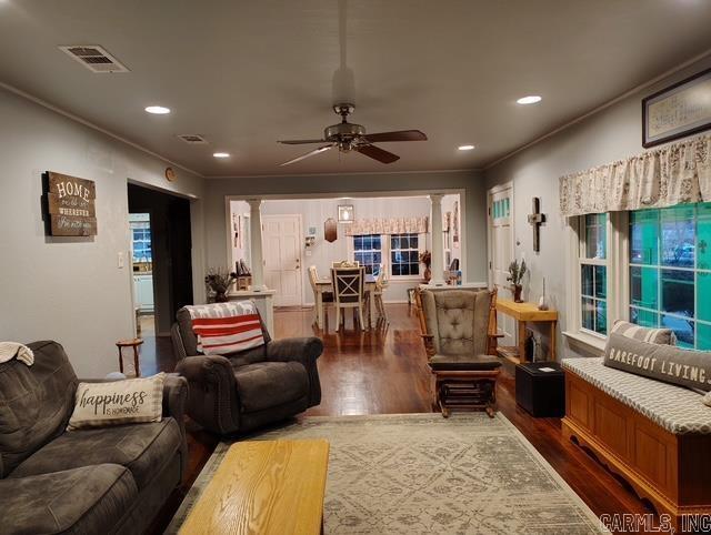 living room featuring recessed lighting, visible vents, dark wood-type flooring, and ornamental molding