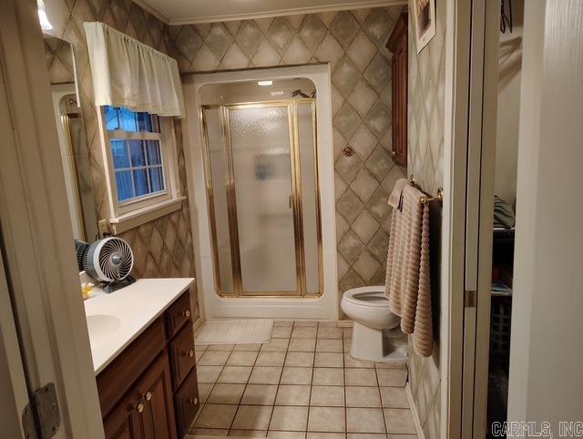 bathroom featuring tile walls, toilet, a shower stall, vanity, and tile patterned flooring