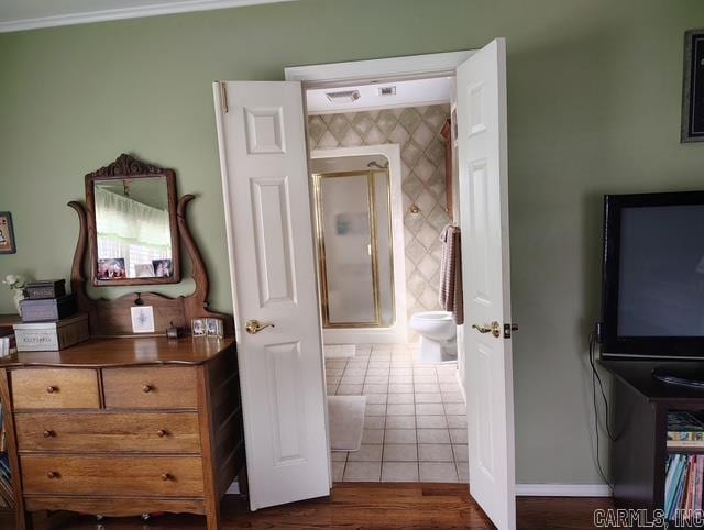 bedroom featuring baseboards, ornamental molding, and dark tile patterned flooring