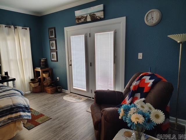 bedroom featuring ornamental molding, wood finished floors, and baseboards