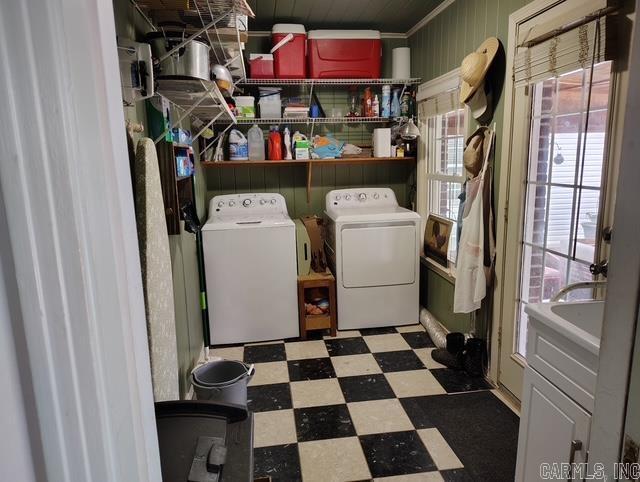 clothes washing area featuring laundry area, washer and dryer, and tile patterned floors