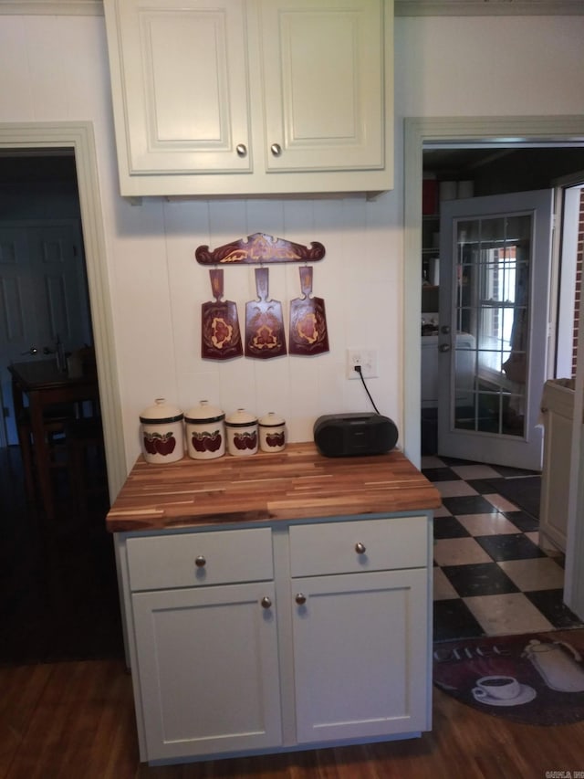 kitchen with dark floors, white cabinets, and wooden counters