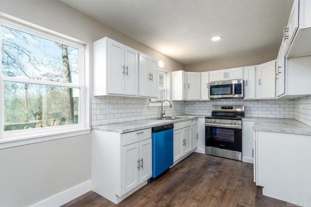 kitchen featuring decorative backsplash, appliances with stainless steel finishes, dark wood finished floors, and a sink