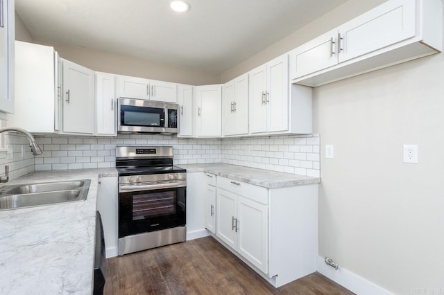 kitchen featuring tasteful backsplash, stainless steel appliances, a sink, and light countertops