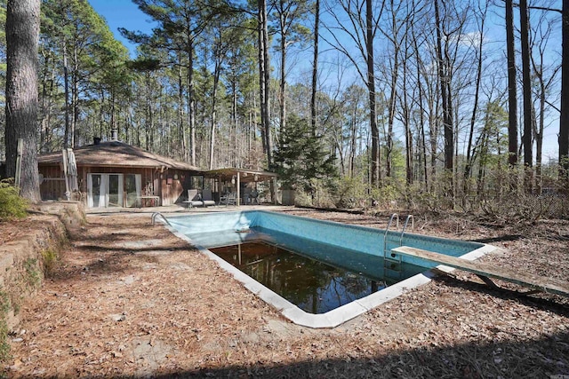 view of pool featuring an empty pool and a diving board