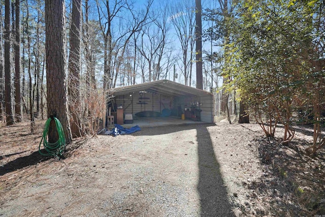 exterior space featuring dirt driveway and a detached carport