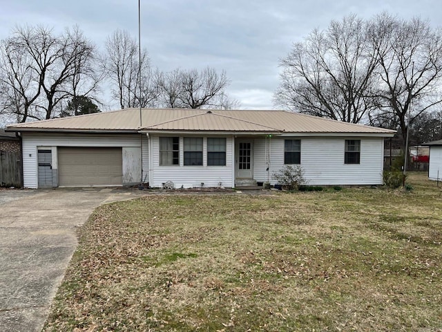 ranch-style home with a garage, metal roof, a front lawn, and driveway