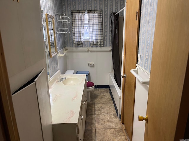 bathroom featuring toilet, shower / tub combo, vanity, tile patterned flooring, and wallpapered walls