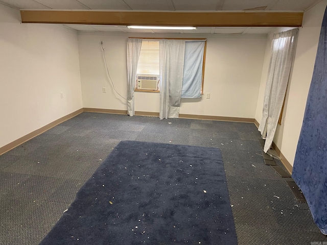 unfurnished room with cooling unit, a drop ceiling, and baseboards