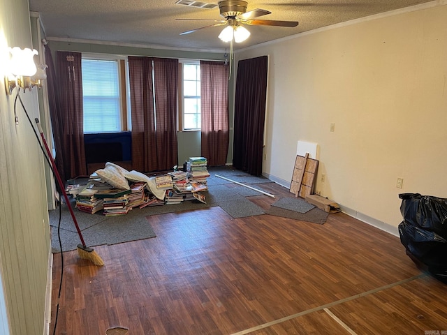 interior space featuring visible vents, crown molding, a textured ceiling, and wood finished floors