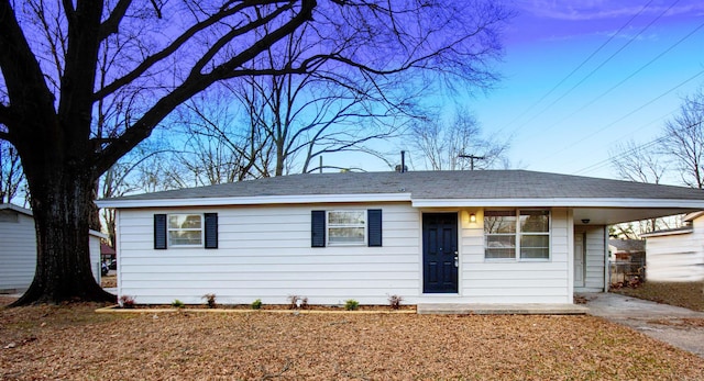 ranch-style house featuring an attached carport and concrete driveway