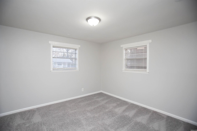 unfurnished room featuring carpet and baseboards