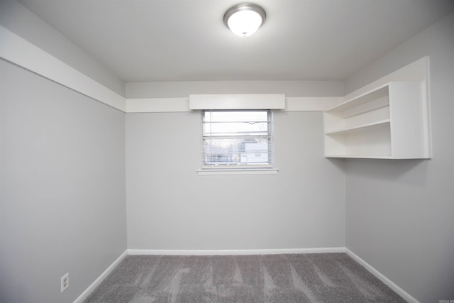 carpeted spare room featuring baseboards