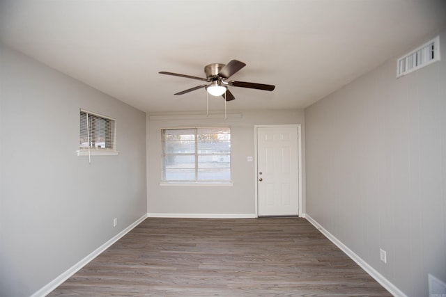 spare room with visible vents, ceiling fan, baseboards, and wood finished floors