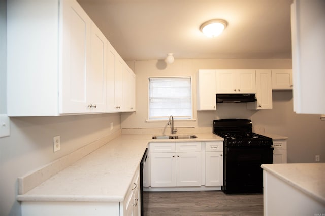 kitchen featuring light countertops, white cabinetry, a sink, under cabinet range hood, and black appliances