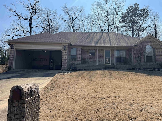 ranch-style home with brick siding, a shingled roof, concrete driveway, an attached garage, and a front yard