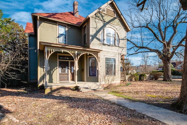 victorian home with a chimney and a porch