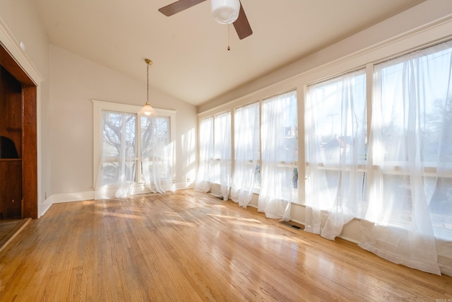 unfurnished sunroom featuring visible vents, vaulted ceiling, and a ceiling fan