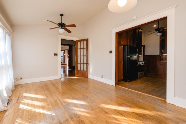 empty room featuring ceiling fan, baseboards, and wood finished floors