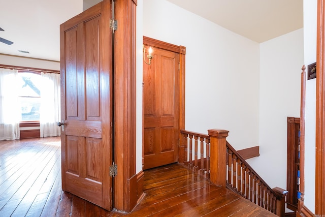 corridor with hardwood / wood-style flooring and an upstairs landing