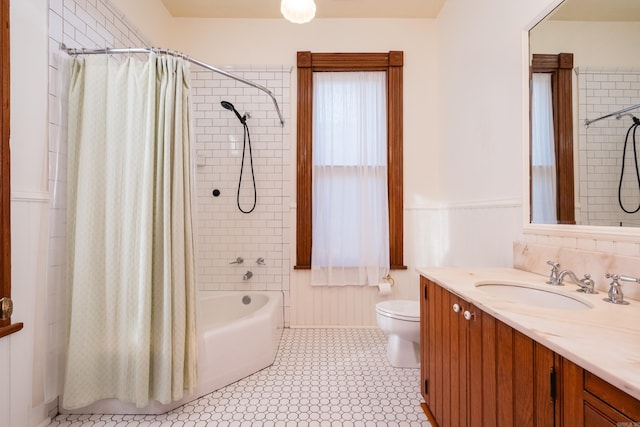 bathroom featuring shower / bath combo, wainscoting, vanity, and toilet