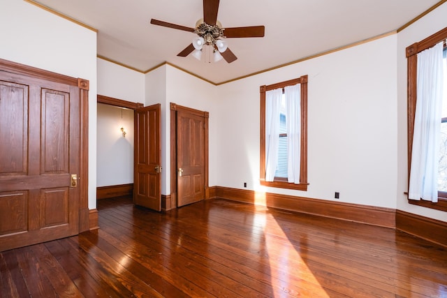 unfurnished bedroom featuring ceiling fan, ornamental molding, wood-type flooring, and baseboards