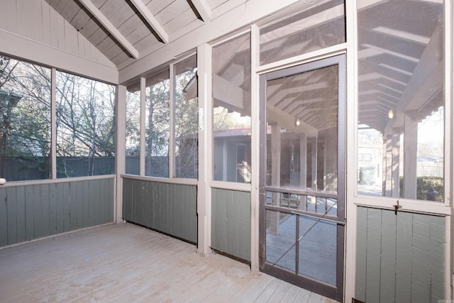 unfurnished sunroom with lofted ceiling with beams, wood ceiling, and a wealth of natural light