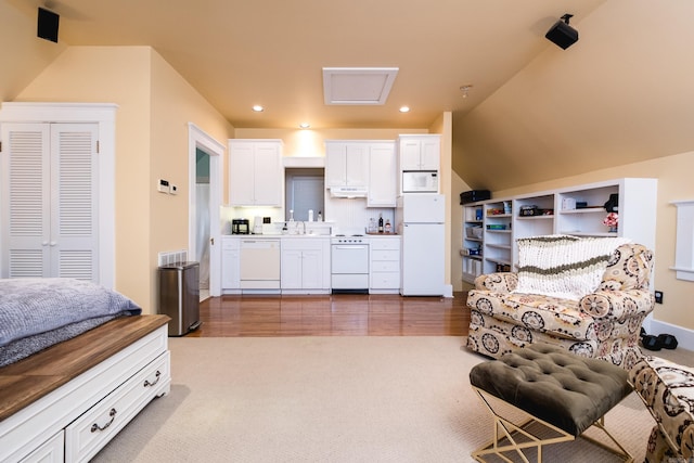 carpeted living area featuring lofted ceiling, a sink, and recessed lighting