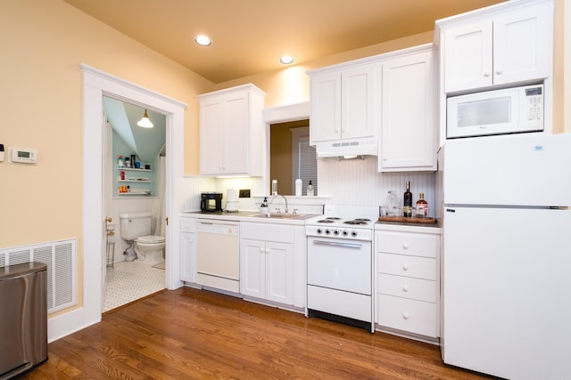 kitchen with under cabinet range hood, white appliances, a sink, visible vents, and white cabinets