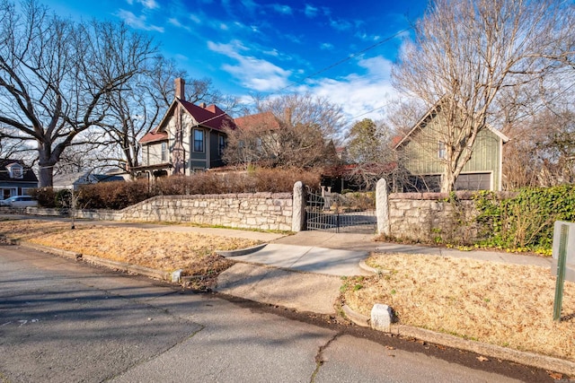 exterior space with aphalt driveway and a gate