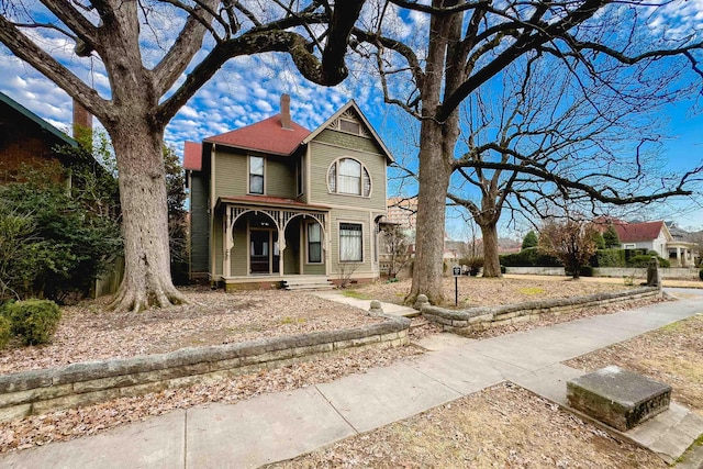 victorian home with a porch and a chimney