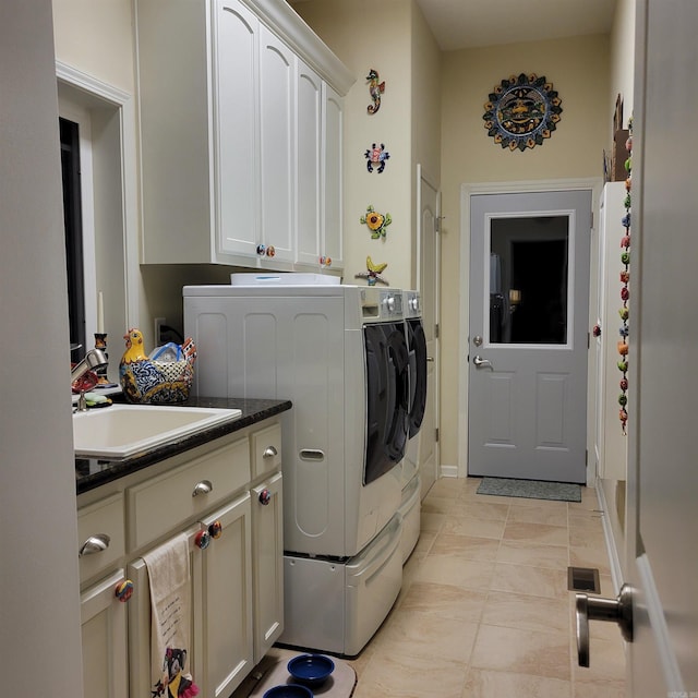 laundry room featuring cabinet space, separate washer and dryer, and a sink