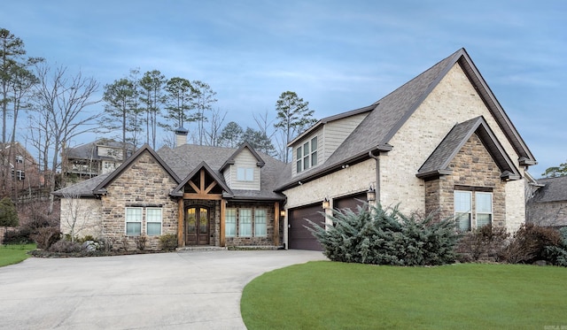 view of front facade with french doors, concrete driveway, a garage, stone siding, and a front lawn